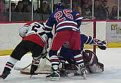 Falcons forward Shane Fukushima (27) tries to stuff the puck past New England's Ryan Thomson while Chris Grotnes (25) moves him out of the way.  (Photos by Erik W. L. Anderson)