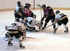 Superior's Randy Currie (4) kicks the loose puck away from Falcon Matt Elsen (12) during a major River Falls power play.