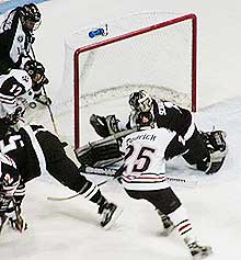 Providence goaltender Nolan Schaeffer stops Northeastern's Trevor Reschney (17) on a wrap-around bid as Brian Tudrick (25) sits on the  doorstep. (photos by Jim Connelly)