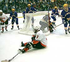 RIT's Mike Tarantino continues to play the puck despite falling down. (photos by Russell Jaslow)