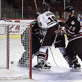 UMass freshman Stephen Werner is pushed into Northeastern goalie Keni Gibson by Brian Swiniarski after assisting on Jeff Lang's gamewinner.  (Photos by James Schaffer)