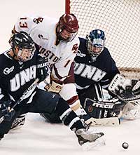 UNH's Mike Lubesnick holds off Tony Voce's attempt to deflect the puck past goalie Michael Ayers.