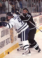 UNH's Sean Collins battles with Providence freshman Matt Mannina behind the Friars' net.