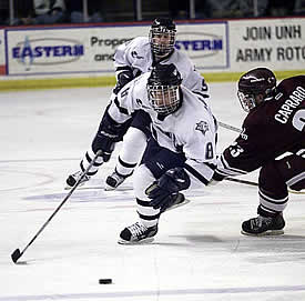 UNH's Steve Saviano works his way around UMass freshman Chris Capraro.  Saviano assisted on the OT gamewinner. (Photos by James Schaff)