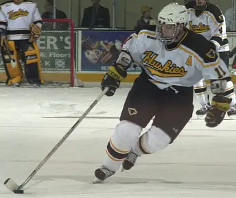 Murphy gathers the puck and heads up the ice.