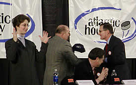 AHA commisioner Bob DeGregorio presents Simone with an AHA hat as Tim Dillon, Canisius AD, and an interpreter for the deaf look on.