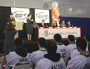 Members of the RIT hockey team look on as RIT president Al Simone speaks.