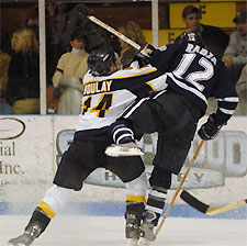 Merrimack's Brian Boulay (14) checks UNH's Mike Radja (12) during the third period of Tuesday night's Hockey East matchup at Lawler Arena. (photo: Josh Gibney)