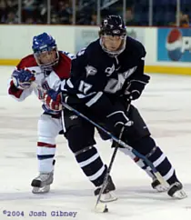 UNH's Dan Travis, defended by UML's Todd Fletcher, carries the puck in during the first period (photos: Josh Gibney).