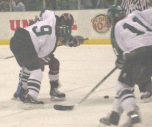 Harvard's Julie Chu and Dartmouth's Meagan Walton (9) battle on a faceoff, while Gillian Apps (11) eyes the puck.