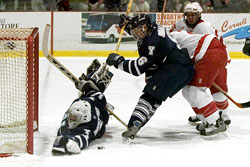 Yale goalie Matt Modelski (l.) goes puck-hunting during Cornell's Friday win (photo: ELynah.com).