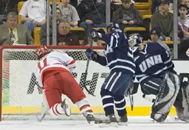 Dan Spang (l.) falls as he gets the puck into an open net.