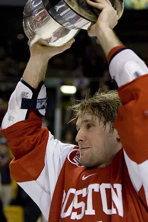 Overtime hero Brian McGuirk of BU hoists the Beanpot Monday night (photos: Melissa Wade).