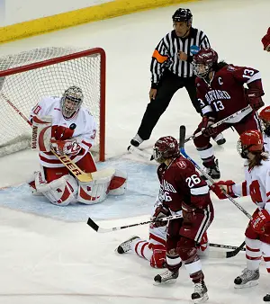 Julie Chu (13) and Sarah Vaillancourt (26) put pressure on Badger goalie Jessie Vetter. / John E. Van Barriger (<a href='http://words-photos.com'></noscript>words-photos.com)” /><p></p>
<div class=