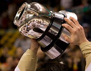 The BC players are reflected in the Beanpot trophy.