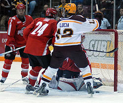 Justin Bostrom's first-period goal (puck at lower right) rolls toward the net in front of Minnesota's Tony Lucia (right) (photo: Jason Waldowski).