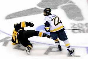 Lincoln Schrock (22) lays a check on a Gustavus player (photo: Angelo Lisuzzo).