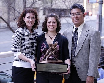 Elumba with the Humanitarian Award, flanked by her parents (photo: Jim Rosvold). 