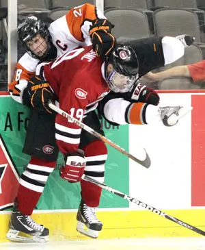 St. Cloud State's Drew LeBlanc knocks RIT's Andrew Favot off his skates during Friday's opening game of the Mutual of Omaha Stampede at Qwest Center Omaha. St. Cloud State won 3-1 (photo: Michelle Bishop).