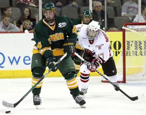 Clarkson's David Pratt brings the puck up ice as UNO's Terry Broadhurst looks on (photo: Michelle Bishop). 