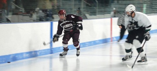 Brennan Quackenbush (right) lines up an opposing forward on the boards.